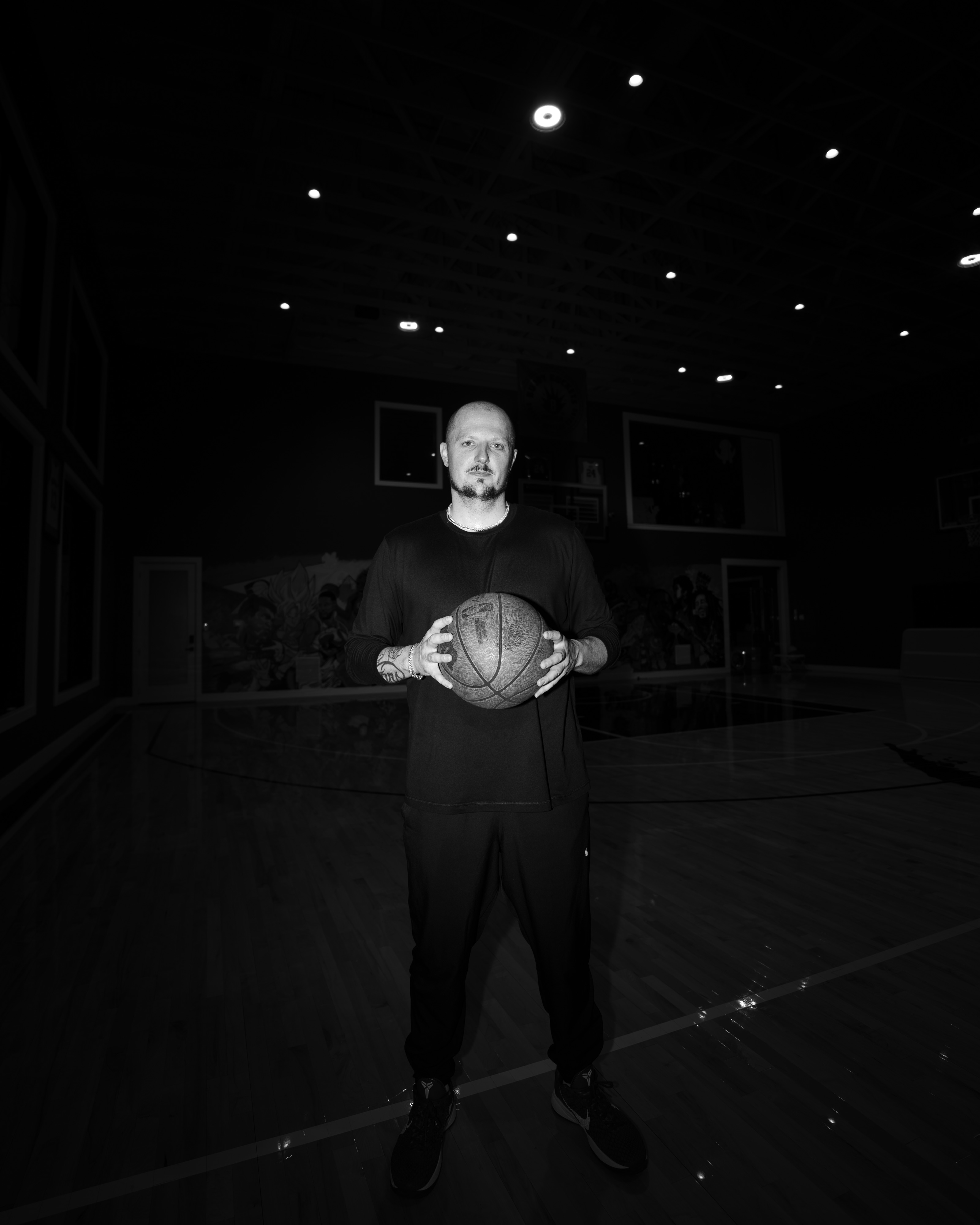 Trey Slate holding a basketball on court and looking toward the camera.